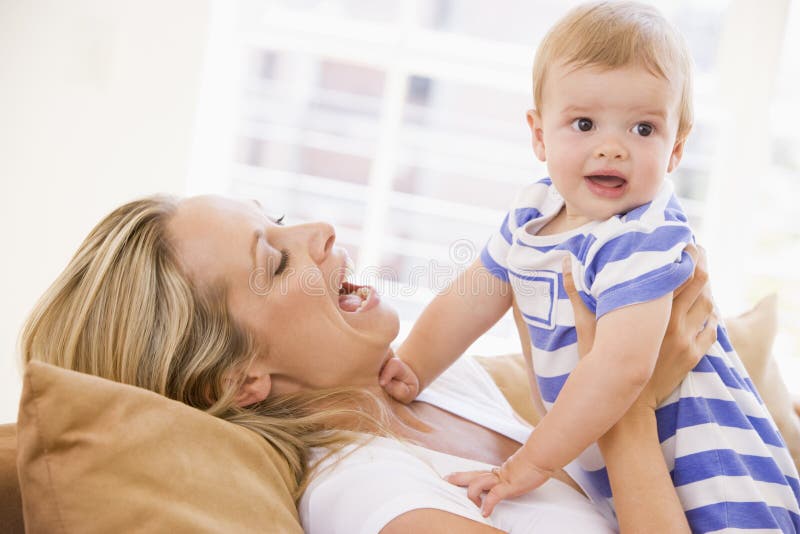 Moeder in de baby van de woonkamerholding stock afbeeldingen Moeder in de baby van de woonkamerholding stock afbeeldingen