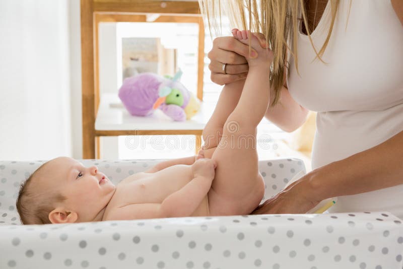 Moeder die de luier van haar baby veranderen royalty-vrije stock afbeeldingen Moeder die de luier van haar baby veranderen royalty-vrije stock afbeeldingen