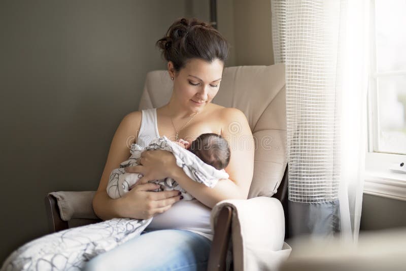 Moeder die haar de borst geven weinig babyjongen in wapens stock foto Moeder die haar de borst geven weinig babyjongen in wapens stock foto