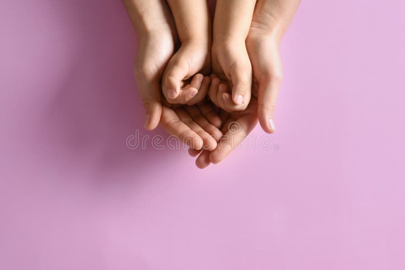 Moeder die handen vasthoudt aan haar kind op roze achtergrond Fijne familie stock foto Moeder die handen vasthoudt aan haar kind op roze achtergrond Fijne familie stock foto