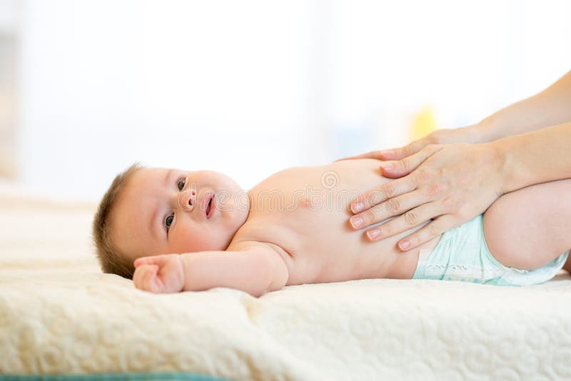 Moeder die schreeuwende baby met koliek masseren royalty-vrije stock foto's Moeder die schreeuwende baby met koliek masseren royalty-vrije stock foto's