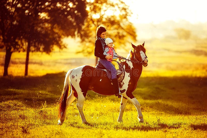 Moeder en dochter die een paard berijden stock foto Moeder en dochter die een paard berijden stock foto