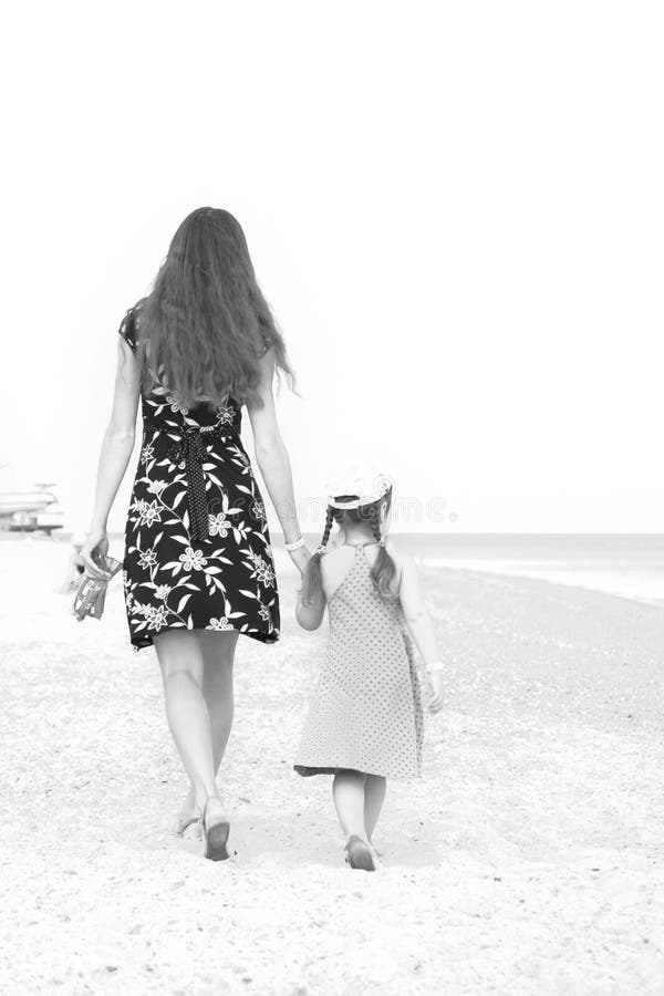 Moeder en dochter die op strand lopen. Zwart-wit. royalty-vrije stock afbeeldingen Moeder en dochter die op strand lopen. Zwart-wit. royalty-vrije stock afbeeldingen