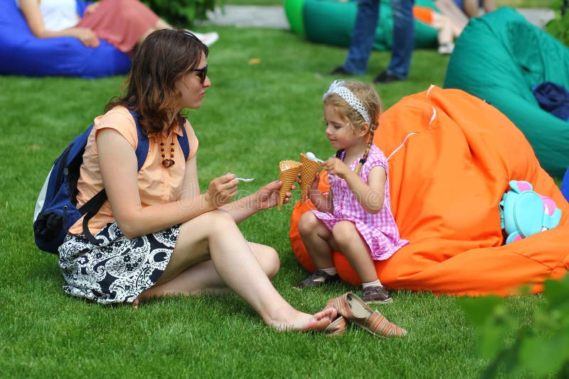 Moeder en dochter die roomijs in het de zomerpark eten royalty-vrije stock fotografie Moeder en dochter die roomijs in het de zomerpark eten royalty-vrije stock fotografie