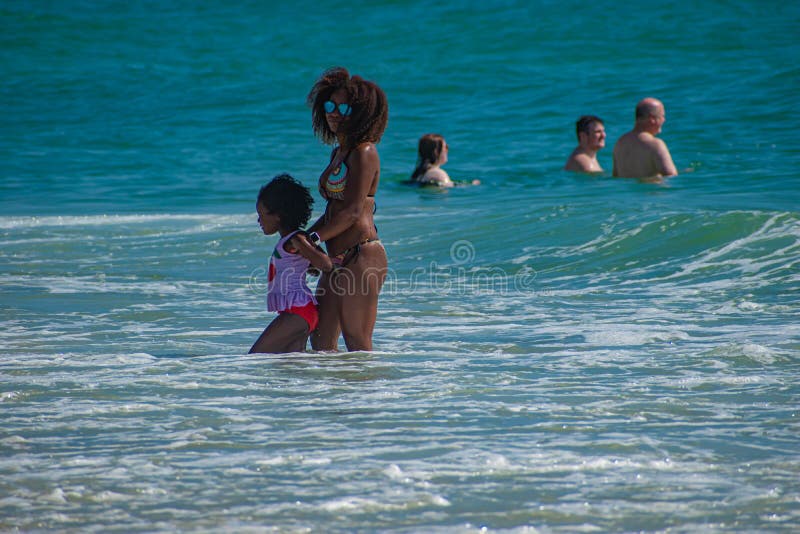 Daytona Beach Florida. July 07, 2019 Mother and daughter enjoying waves and green sea 3. Daytona Beach Florida. July 07, 2019 Mother and daughter enjoying waves and green sea 3