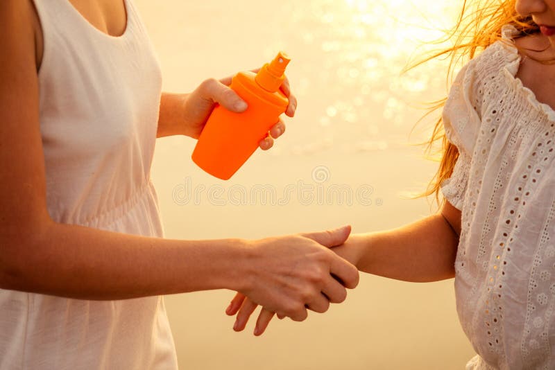 Moeder en dochter die zonnebrandcrème op het lichaam spf aanbrengen stock afbeelding Moeder en dochter die zonnebrandcrème op het lichaam spf aanbrengen stock afbeelding