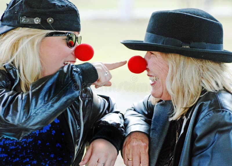 An intimate portrait and look into the loving relationship of a mother and her daughter with this candid outdoor portrait as they both celebrate Red Nose Day in Australia and their expressions show how much fun they are having together, smiling laughing and even poking at each others big red nose. An intimate portrait and look into the loving relationship of a mother and her daughter with this candid outdoor portrait as they both celebrate Red Nose Day in Australia and their expressions show how much fun they are having together, smiling laughing and even poking at each others big red nose.