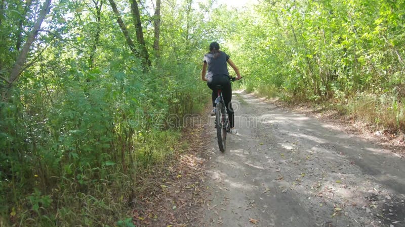 Moeder en dochter rijden in de zomer fietsen in het bos.