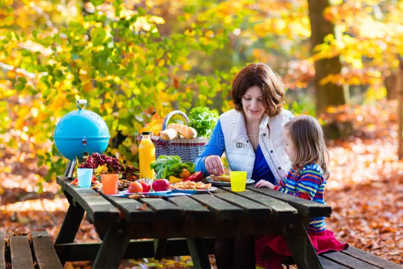 Moeder en dochter vastgestelde lijst voor picknick in de herfst stock afbeelding Moeder en dochter vastgestelde lijst voor picknick in de herfst stock afbeelding