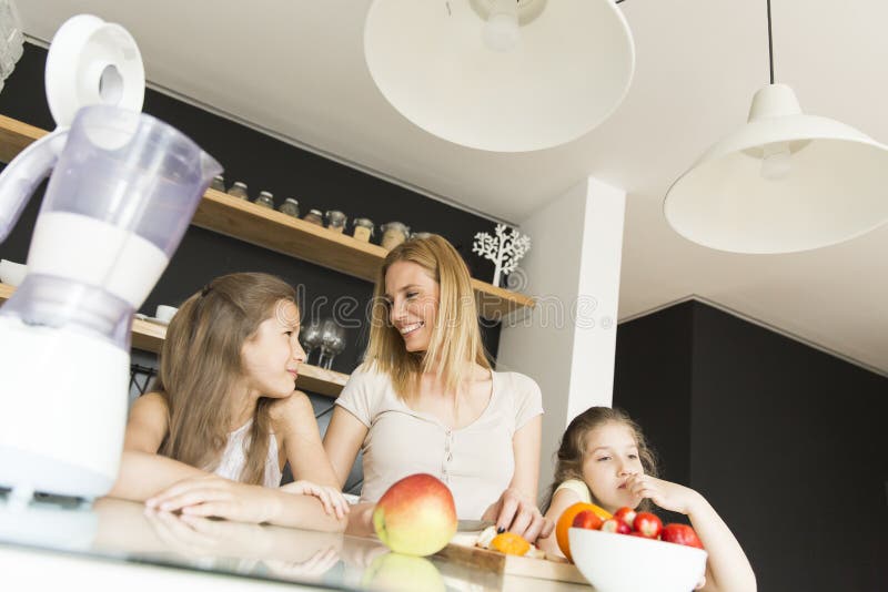 Moeder en dochters in de keuken stock fotografie