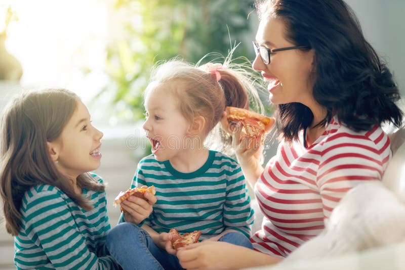Moeder en dochters die pizza eten royalty-vrije stock afbeelding Moeder en dochters die pizza eten royalty-vrije stock afbeelding