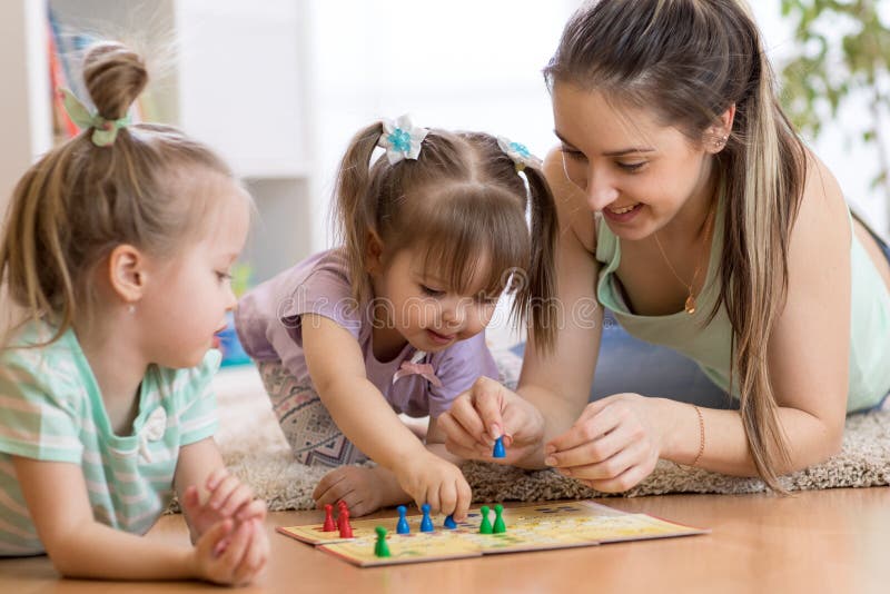 Moeder en haar jonge geitjes die in raadsspel spelen royalty-vrije stock afbeelding Moeder en haar jonge geitjes die in raadsspel spelen royalty-vrije stock afbeelding