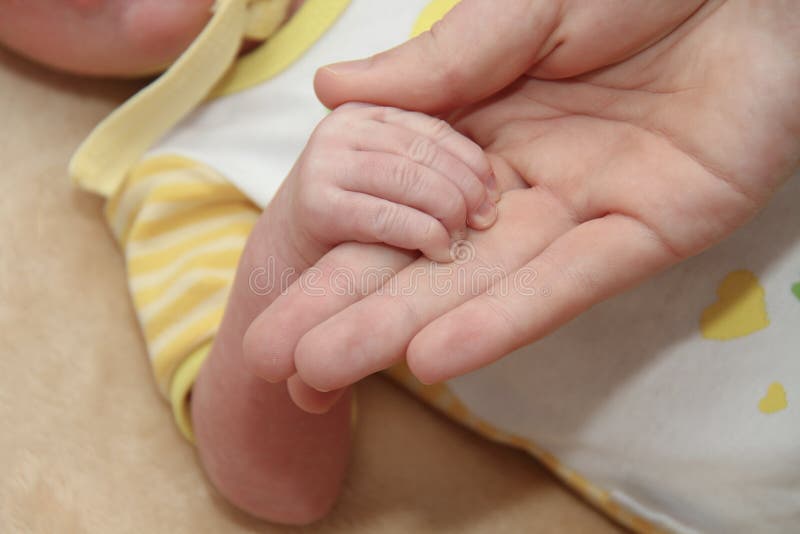 Moeder en haar Pasgeboren Baby, de pasgeborenenhanden van de Ouderholding stock afbeeldingen Moeder en haar Pasgeboren Baby, de pasgeborenenhanden van de Ouderholding stock afbeeldingen
