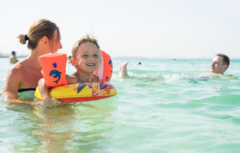 Moeder en haar zoon die en op het strand spelen lopen Concept vriendschappelijke familie stock foto Moeder en haar zoon die en op het strand spelen lopen Concept vriendschappelijke familie stock foto