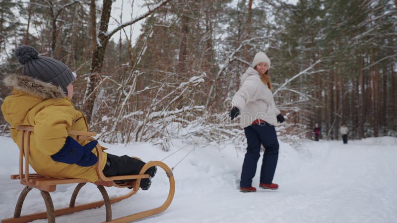 Moeder en kleine zoon brengen tijd door en hebben plezier in het winterbos in het weekend gelukkige familie