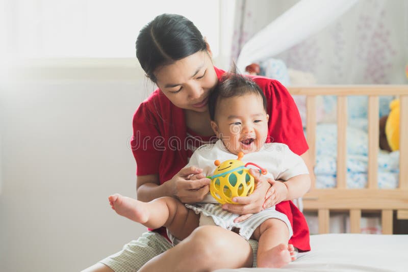 Moeder en nieuw - de geboren baby speelt samen een stuk speelgoed en een pret royalty-vrije stock afbeeldingen Moeder en nieuw - de geboren baby speelt samen een stuk speelgoed en een pret royalty-vrije stock afbeeldingen