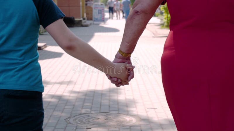 Moeder en zoon die de straten van de stad hand in hand lopen Emotioneel Ogenblik Close-up van hun handen