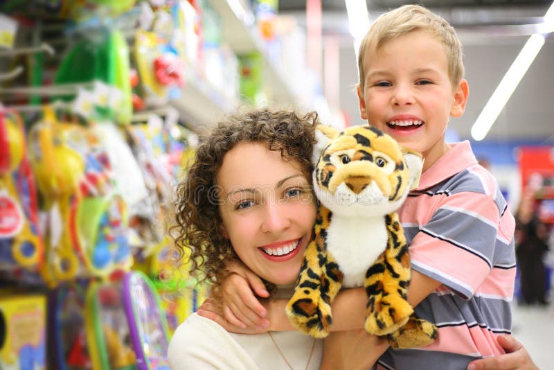 Moeder en zoon met stuk speelgoed in winkel royalty-vrije stock foto Moeder en zoon met stuk speelgoed in winkel royalty-vrije stock foto