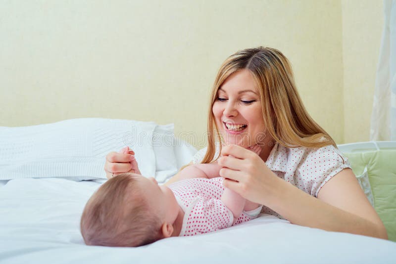 Moeder het spelen met haar baby op het bed Mammaglimlachen aan haar kind stock foto's Moeder het spelen met haar baby op het bed Mammaglimlachen aan haar kind stock foto's