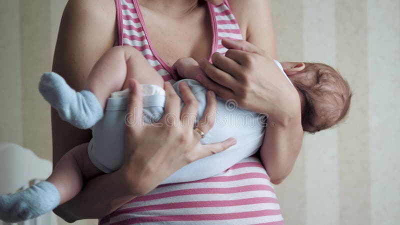 Moeder kruipt baby in haar armen om te kalmeren en pasgeborenen in slaap te laten vallen