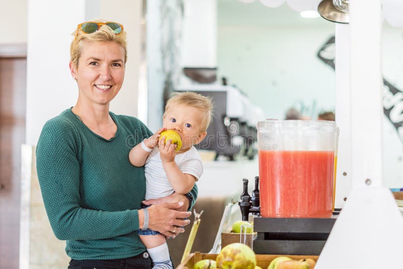 Moeder met babyjongen en appel in al inclusief restaurant stock fotografie Moeder met babyjongen en appel in al inclusief restaurant stock fotografie