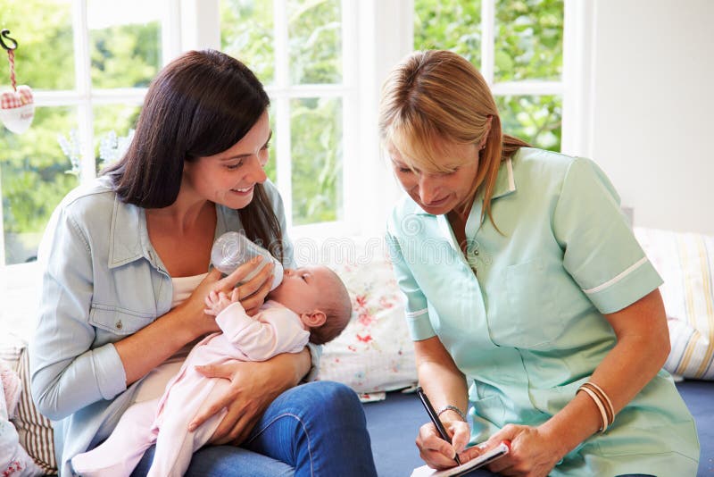 Moeder met Babyvergadering met Gezondheidsbezoeker thuis stock fotografie Moeder met Babyvergadering met Gezondheidsbezoeker thuis stock fotografie