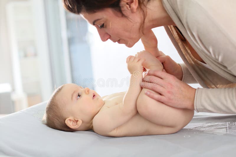 Moeder met haar babyjongen die op de veranderende lijst spelen stock foto's Moeder met haar babyjongen die op de veranderende lijst spelen stock foto's