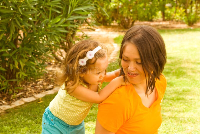 Moeder met het spel van het babymeisje in park stock foto