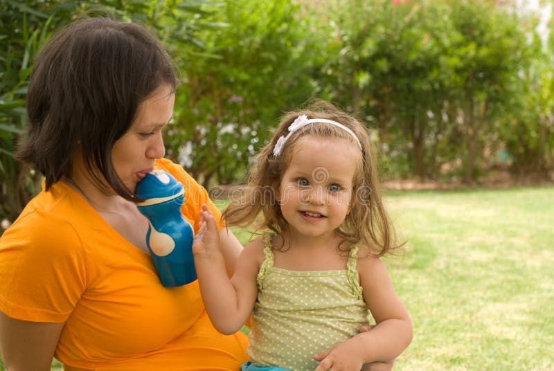 Moeder met het spel van het babymeisje in park stock afbeelding