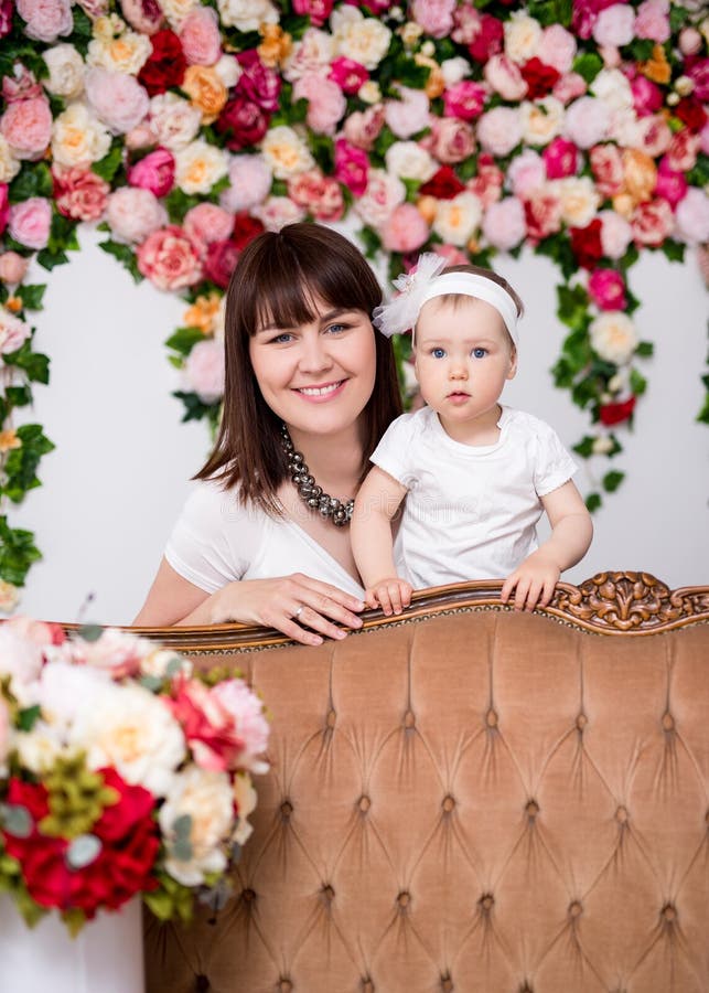 Moederdagconcept - gelukkige mooie moeder en haar weinig dochter over bloemenachtergrond royalty-vrije stock fotografie Moederdagconcept - gelukkige mooie moeder en haar weinig dochter over bloemenachtergrond royalty-vrije stock fotografie