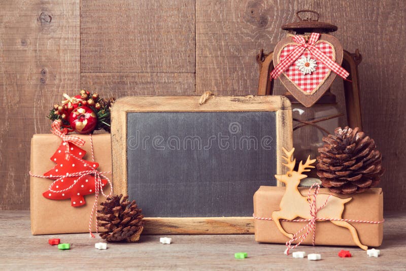 Mofa de la pizarra para arriba con los regalos de la Navidad y las decoraciones rústicas imagen de archivo Mofa de la pizarra para arriba con los regalos de la Navidad y las decoraciones rústicas imagen de archivo