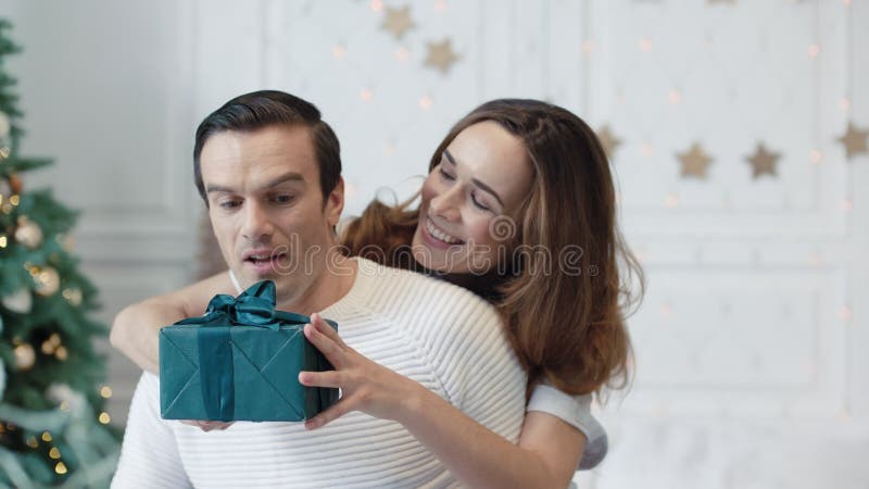 Moglie sorridente che chiede al marito di chiudere gli occhi Una famiglia gioiosa che celebra il nuovo anno