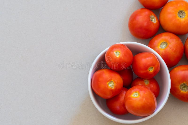 Mogna orange tomater i och runt om den vita bunken arkivbilder Mogna orange tomater i och runt om den vita bunken arkivbilder