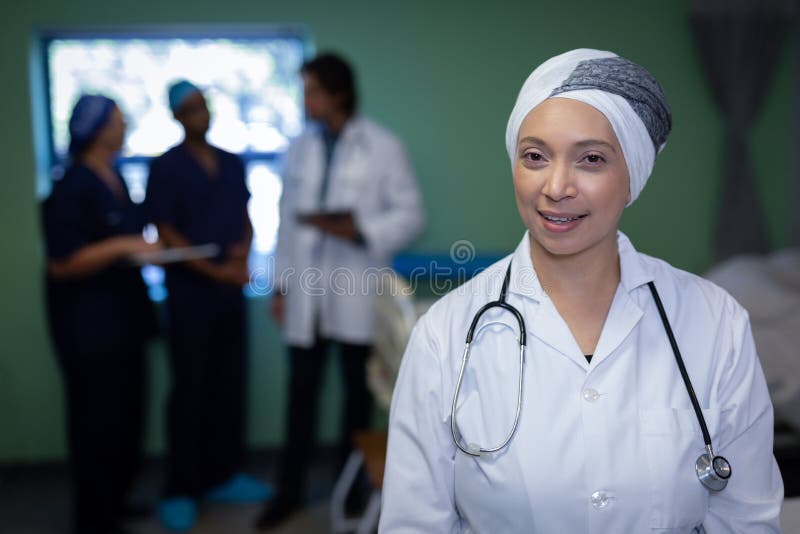 Mognad kvinnlig doktor som ler i klinik på sjukhuset arkivbild Mognad kvinnlig doktor som ler i klinik på sjukhuset arkivbild