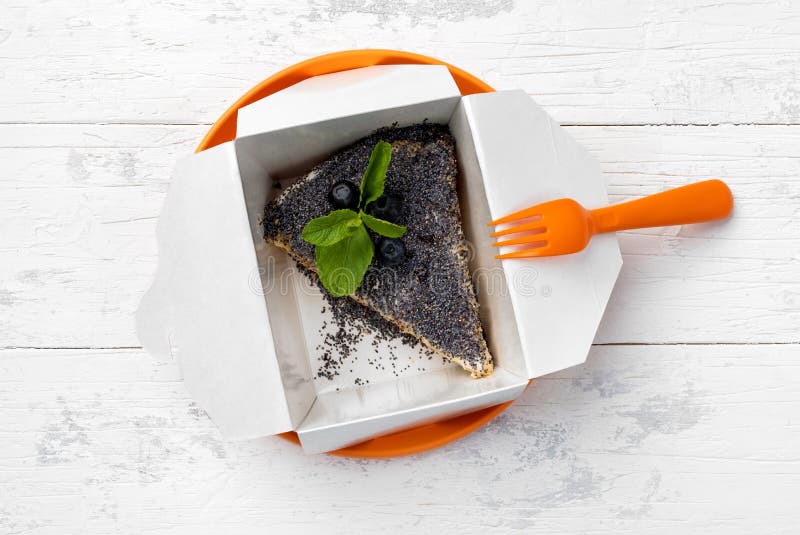 Mohnkuchen mit Blaubeeren im Papierkasten lizenzfreies stockbild Mohnkuchen mit Blaubeeren im Papierkasten lizenzfreies stockbild