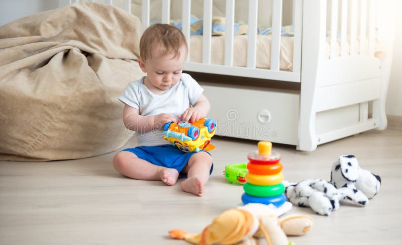 10 Mois Mignons De Garcon D Enfant En Bas Age Jouant Avec La Voiture De Jouet Sur Le Plancher A La Chambre A Coucher Photo Stock Image Du Colore People