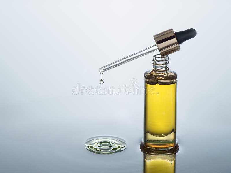 Moisturizing косметическое масло стоит на темной предпосылке воды с выплеском стоковые изображения Moisturizing косметическое масло стоит на темной предпосылке воды с выплеском стоковые изображения