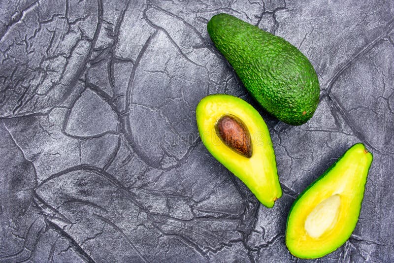 Moitié d'avocat sur le fond noir de la nourriture minimale images libres de droits Moitié d'avocat sur le fond noir de la nourriture minimale images libres de droits