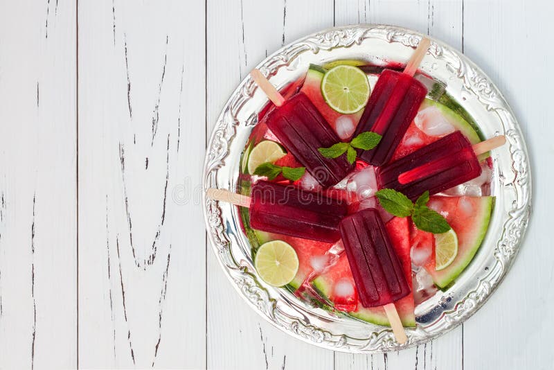 Mojito καρπουζιών popsicles - ο πάγος σκάει - στις φέτες του ώριμου juicy οργανικού καρπουζιού, που εξυπηρετούνται στον εκλεκτής στοκ εικόνα με δικαίωμα ελεύθερης χρήσης Mojito καρπουζιών popsicles - ο πάγος σκάει - στις φέτες του ώριμου juicy οργανικού καρπουζιού, που εξυπηρετούνται στον εκλεκτής στοκ εικόνα με δικαίωμα ελεύθερης χρήσης