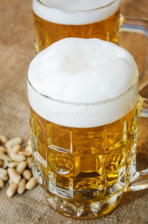 Mok met bier en gezouten pinda's op de lijst royalty-vrije stock foto Mok met bier en gezouten pinda's op de lijst royalty-vrije stock foto