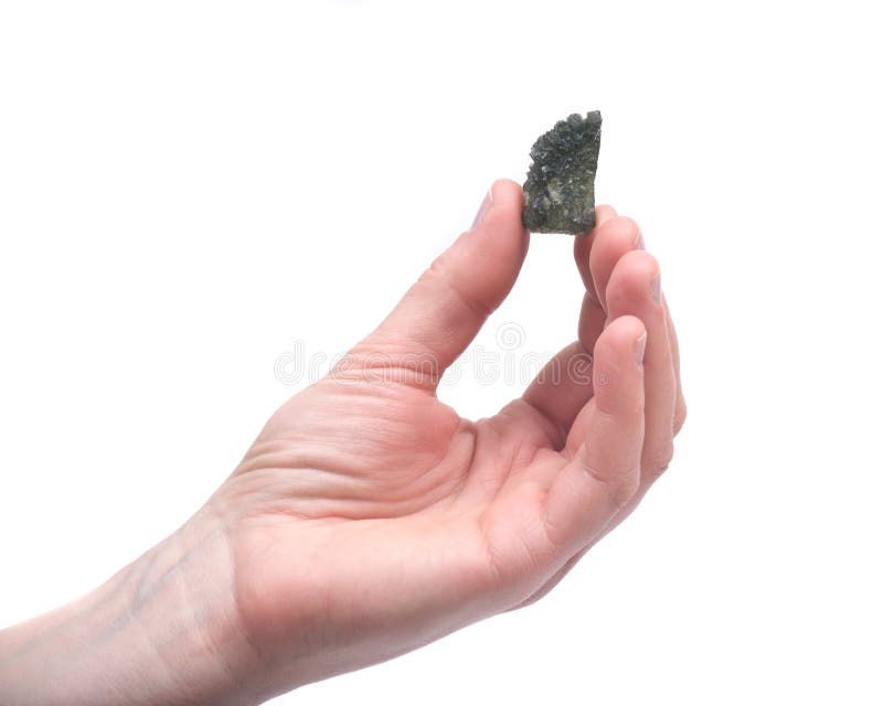 Young woman holding moldavite - form of tektite found along the banks of the river Moldau in Czech republic, isolated on white background. Young woman holding moldavite - form of tektite found along the banks of the river Moldau in Czech republic, isolated on white background