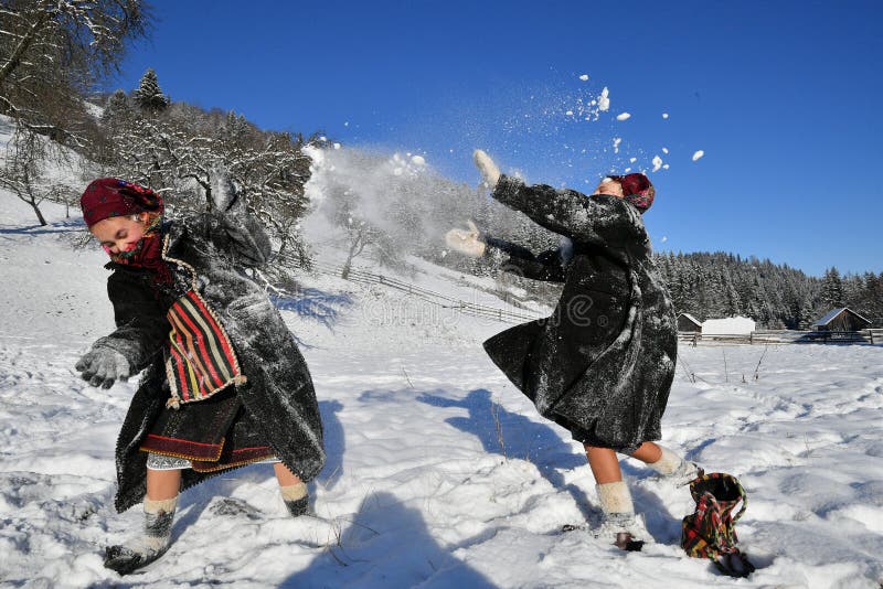 Moldovita, Romania, November 30th, 2018: Children wearing traditional playing with snow in Bucovina