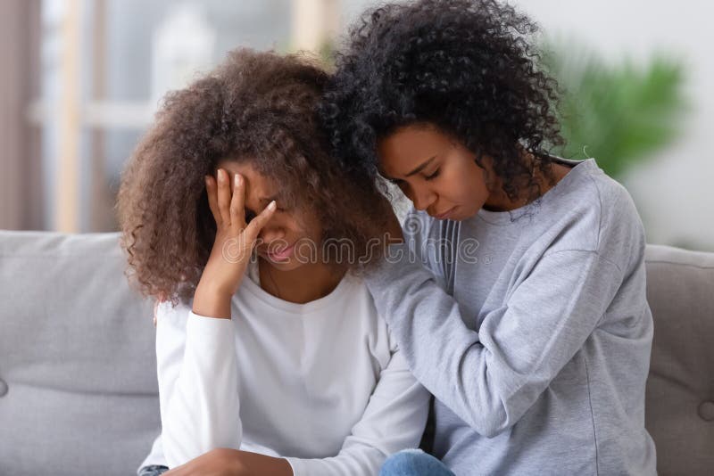 Molesto madre afroamericana abrazando a triste adolescente consolando apoyando