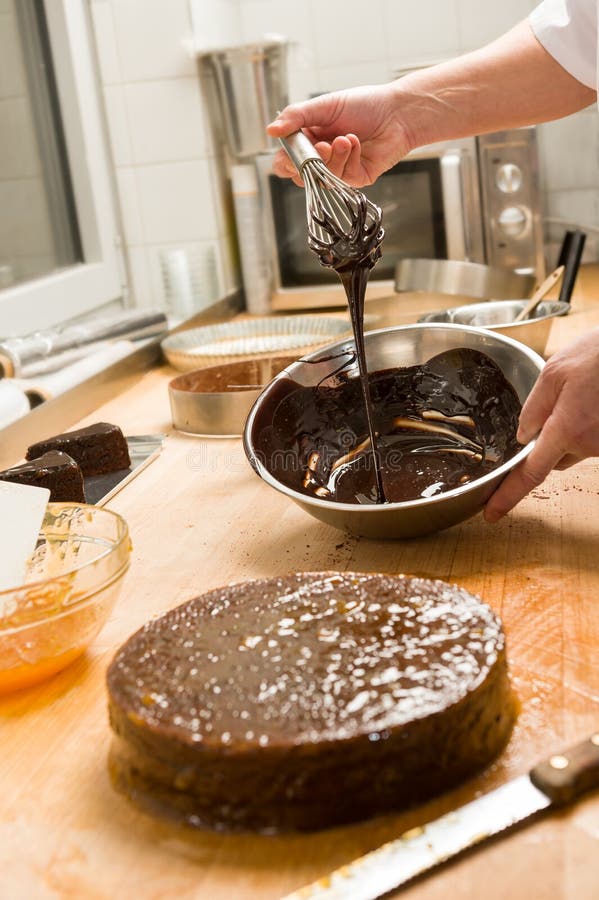 Molho de chocolate do gotejamento da cozinha do cozinheiro para o bolo