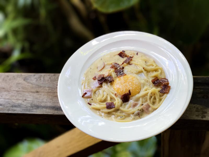 Molho do carbonara dos espaguetes no assoalho de madeira imagem de stock Molho do carbonara dos espaguetes no assoalho de madeira imagem de stock