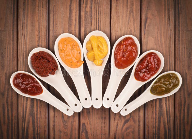 Different sauces are on the wooden background. Different sauces are on the wooden background