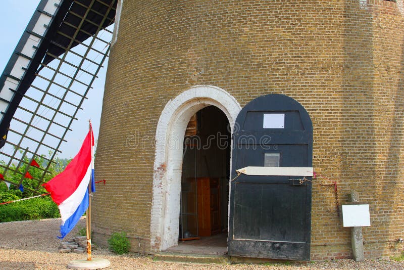 Molino de viento viejo del maíz de la bandera holandesa, Betuwe, Países Bajos foto de archivo Molino de viento viejo del maíz de la bandera holandesa, Betuwe, Países Bajos foto de archivo