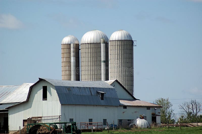 A view of a set of farm buildings in upstate New York including barns and silos. A view of a set of farm buildings in upstate New York including barns and silos.