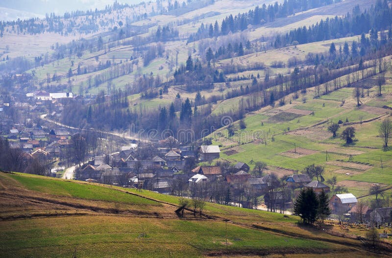 Molla soleggiata in paesino di montagna Campi e colline immagini stock libere da diritti Molla soleggiata in paesino di montagna Campi e colline immagini stock libere da diritti