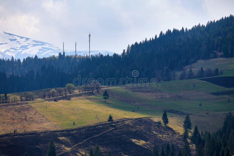 Molla soleggiata in paesino di montagna Campi e colline fotografie stock libere da diritti Molla soleggiata in paesino di montagna Campi e colline fotografie stock libere da diritti
